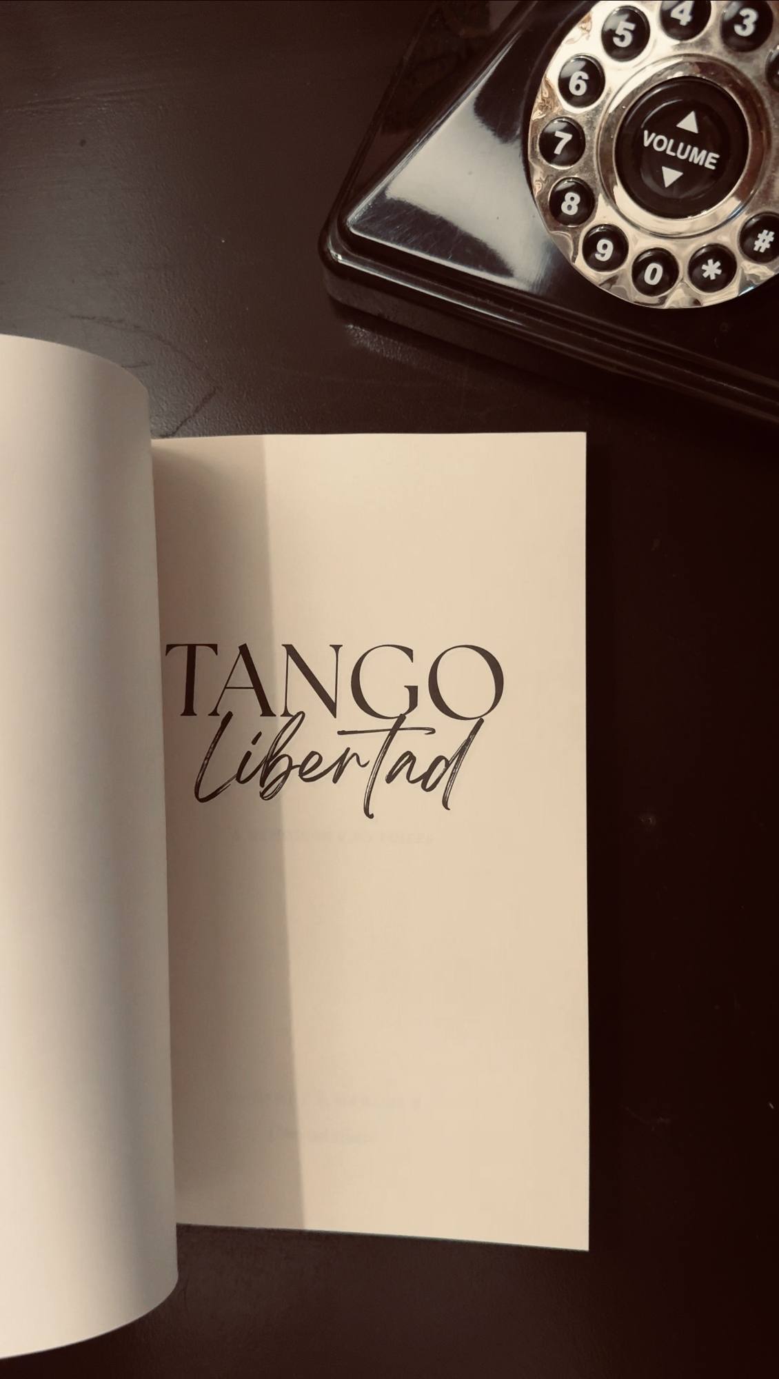 The memoir open to its title page beside a vintage telephone